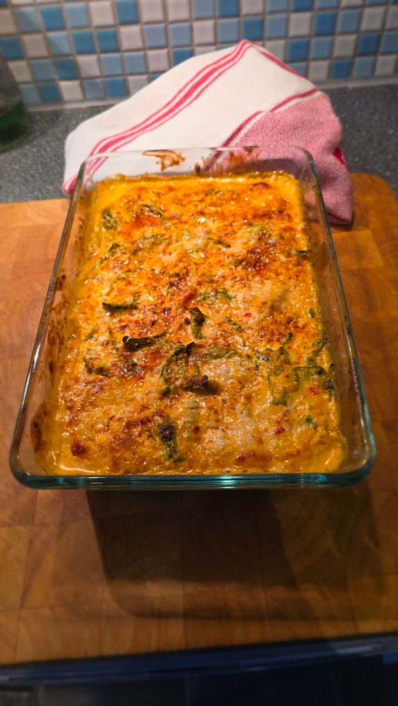 Färdig kyckling i krämig paprikapestosås med spenat och parmesan i ugnsform.
